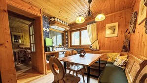 Interior acogedor de una cabaña con una mesa de comedor de madera, sillas y un banco.