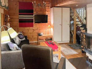 Una sala de estar acogedora con sofá, mesa de centro, televisor y chimenea.