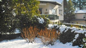 Un giardino innevato con un edificio sullo sfondo.