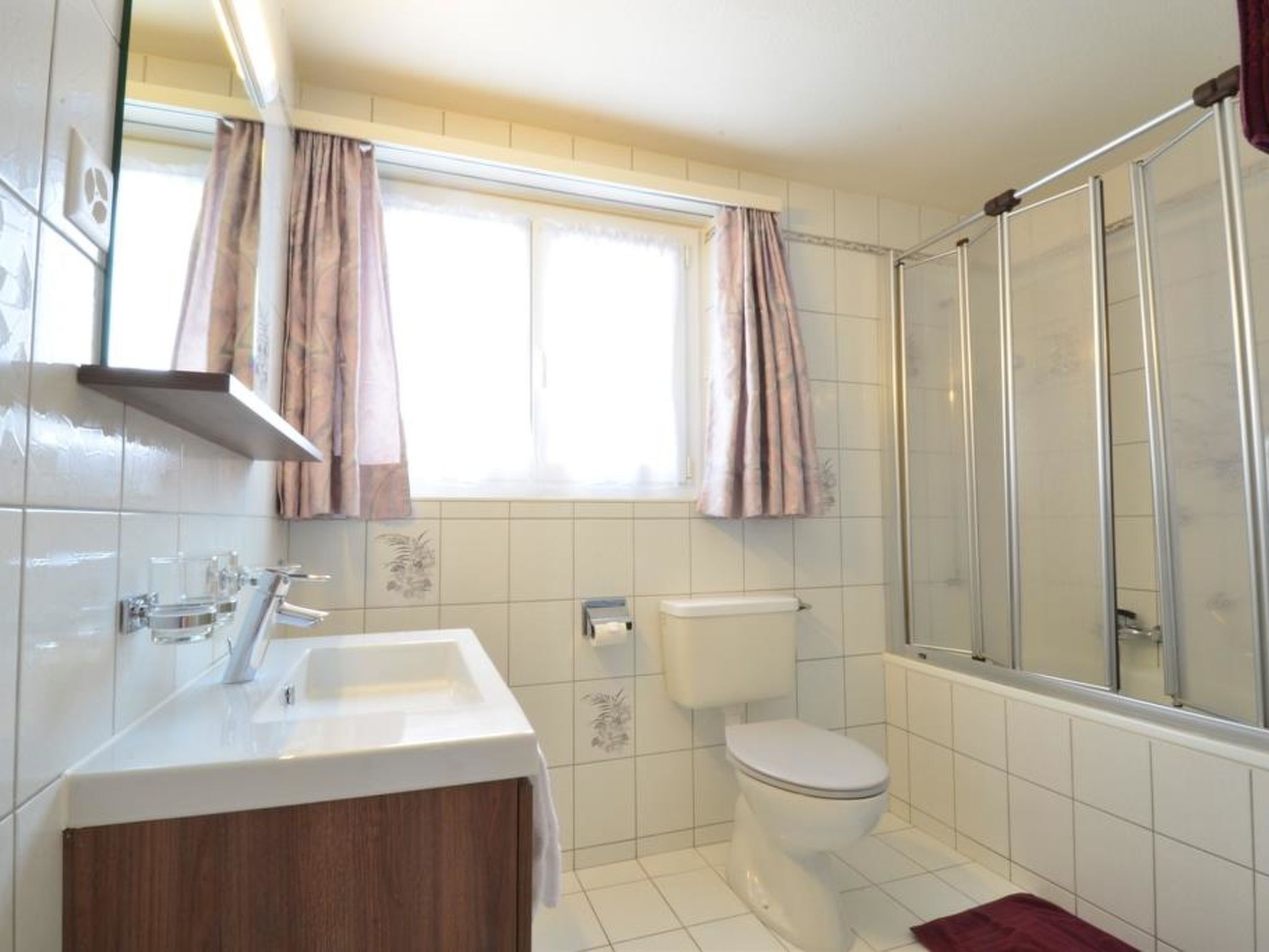 A bathroom with a white sink, toilet, and shower.
