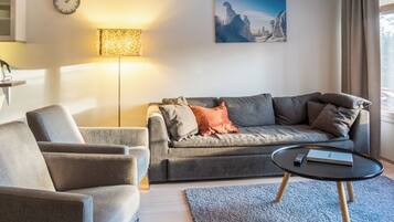 Ett modernt vardagsrum med en soffa, en fåtölj och ett soffbord.