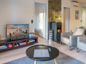 Una sala de estar moderna con un televisor de pantalla plana, una chimenea y un espacio de estar acogedor.