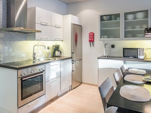 Une cuisine moderne équipée d’appareils électroménagers en acier inoxydable, d’une machine à café et d’un four à micro-ondes.