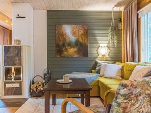 A cozy living room with a fireplace, a painting on the wall, and a comfortable sofa. - Kaakonnokka by Interhome (Ikaalinen)
