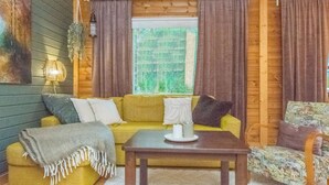 Una habitación acogedora con un sofá, una mesita y una silla.