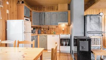 Una cucina compatta con mobili in legno, un fornello, una lavastoviglie e un frigorifero.