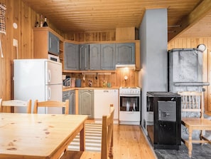 Cuina compacta amb armaris de fusta, fornet, rentaplats i nevera.