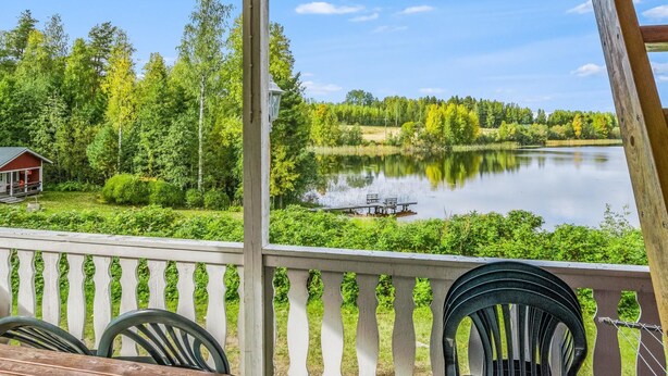 Une terrasse en bois offrant une vue sur un lac et une forêt.