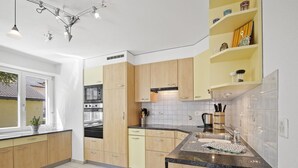 A modern kitchen with wooden cabinets, a built-in oven, and a granite countertop. - Apartment Ruggli by Interhome (Churwalden)