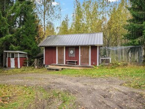 A small, single-story wooden cabin with a metal roof, a front porch, and a target on the door. - Iltaniemi by Interhome (Enonkoski)