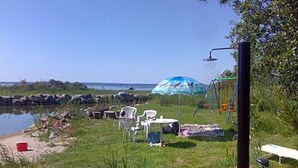 A beachside setting with a water body, a swing set, and outdoor seating. - Soukonranta by Interhome (Pori)
