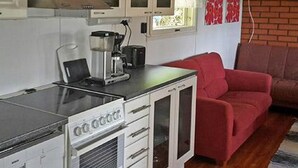 A compact kitchen with a coffee maker, a red sofa, and a brick wall. - Soukonranta by Interhome (Pori)