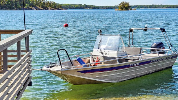 Un bateau était amarré à un quai, d’où l’on pouvait admirer une vue dégagée sur un lac et le rivage au loin.