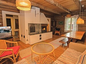 Un intérieur de chalet chaleureux avec une cheminée, des meubles en bois et un téléviseur.