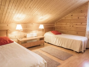 Ein gemütliches Zimmer mit zwei Betten, einem Nachttisch und zwei Nachttischlampen.