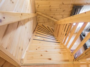 Eine Holztretreppe mit Blick auf einen Wohnbereich.