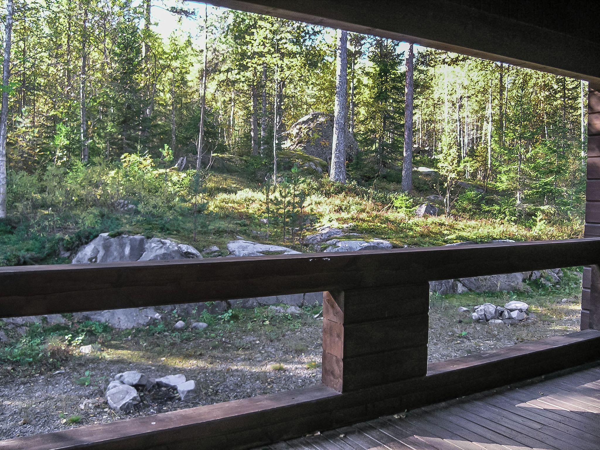 Une terrasse en bois offrant une vue sur une zone boisée.