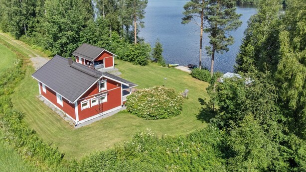 A red house with a sloped roof, a garage, and a small deck. - Talvikki by Interhome (Kuopio)