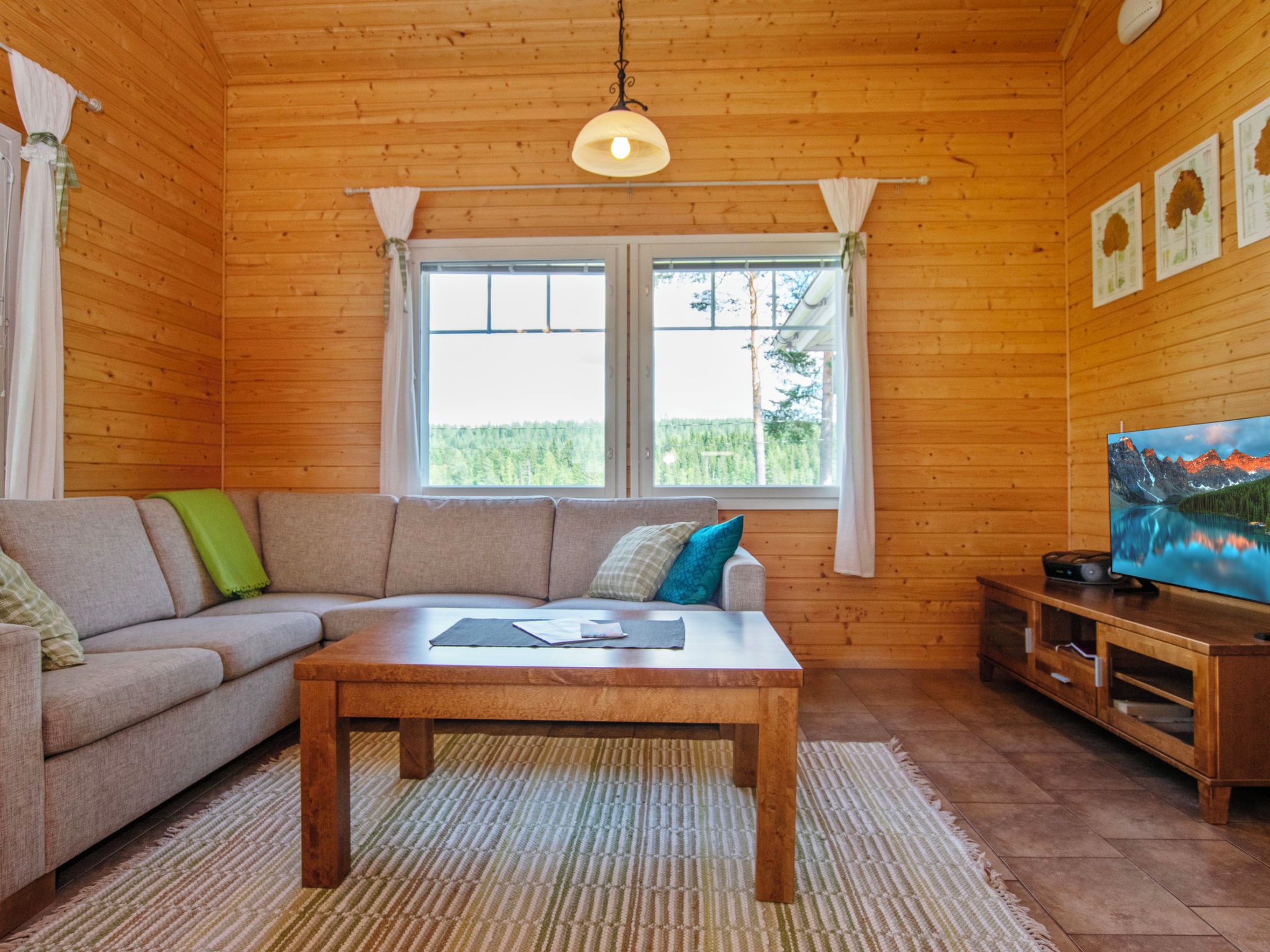 A cozy living room with a sofa, a coffee table, and a television on a wooden stand.