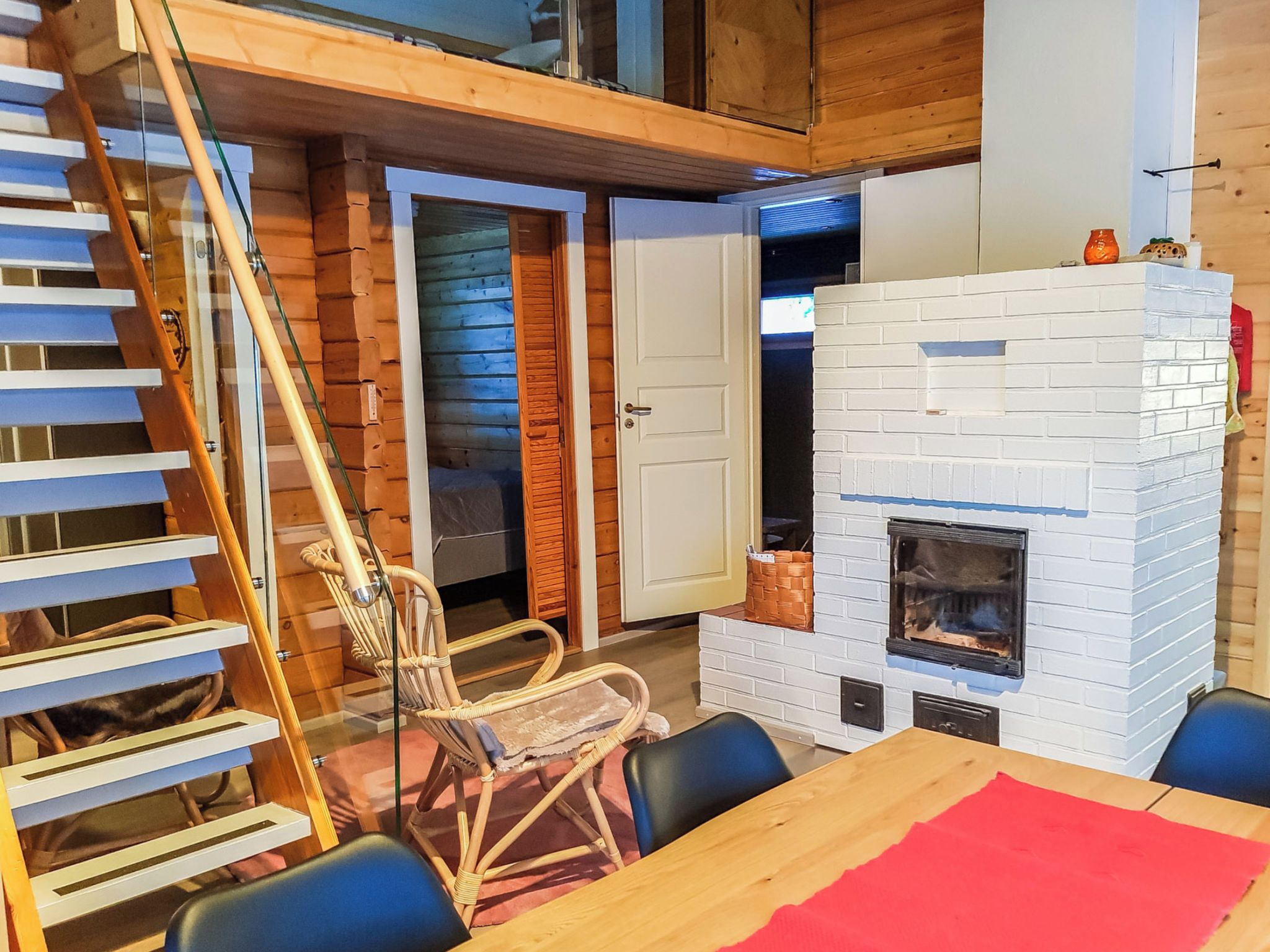 A cozy room with a fireplace, a dining table, and a chair.