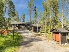 A gravel pathway leading to a row of cabins with a forest backdrop.