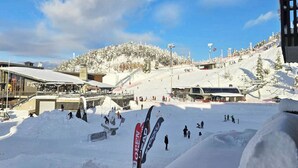 A ski resort with a snow-covered landscape, a ski lift, and a building with a sign that reads 'OPEN HEADQUARTERS.'