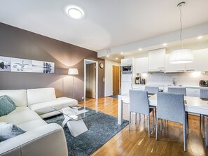 Una sala de estar moderna con un sofá, una mesa de centro y una obra de arte en la pared.