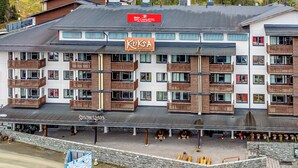 A multi-story hotel with balconies, a ski chalets sign, and a restaurant named 'Kuks.'