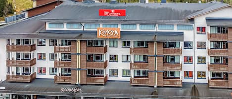 A multi-story hotel with balconies, a ski chalets sign, and a restaurant named 'Kuks.'