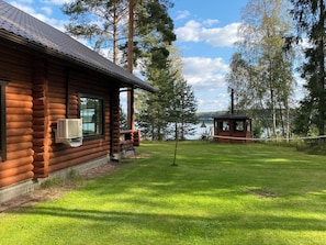 A log cabin with a covered porch and a view of a lake. - Raatiannokka by Interhome (Ikaalinen)