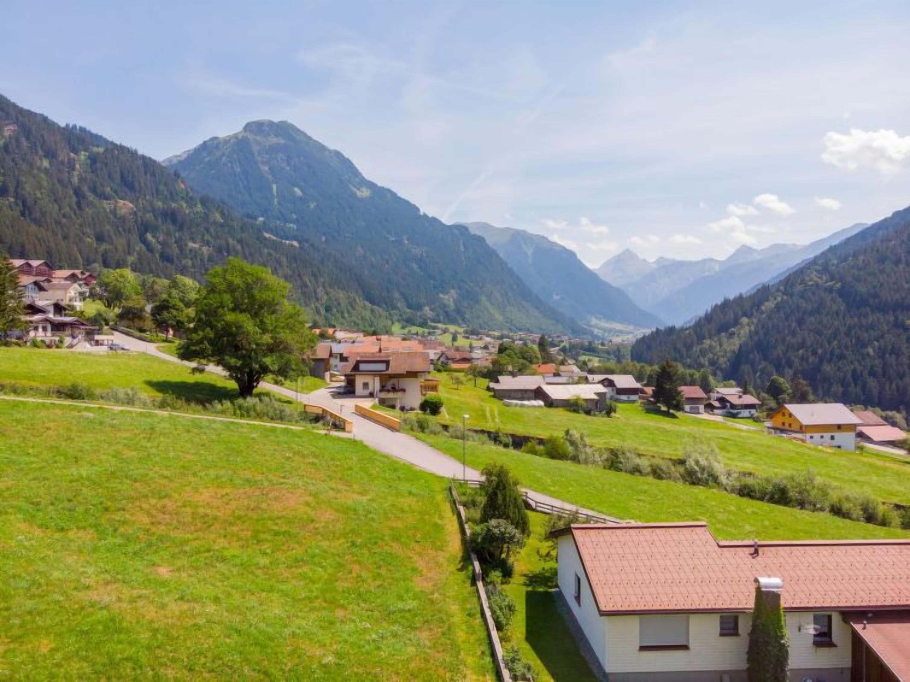 A rural village with houses surrounded by mountains.