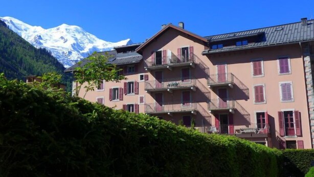 A multi-story building with balconies, set against a backdrop of snow-capped mountains. - L'Univers by Interhome (Chamonix)