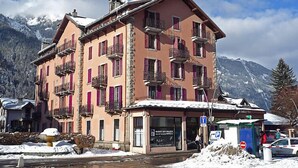 A multi-story building with balconies, a snow-covered roof, and a mountain backdrop. - L'Univers by Interhome (Chamonix)