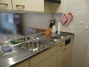 Una cucina con elettrodomestici in acciaio inossidabile, un lavello e mobili in legno.