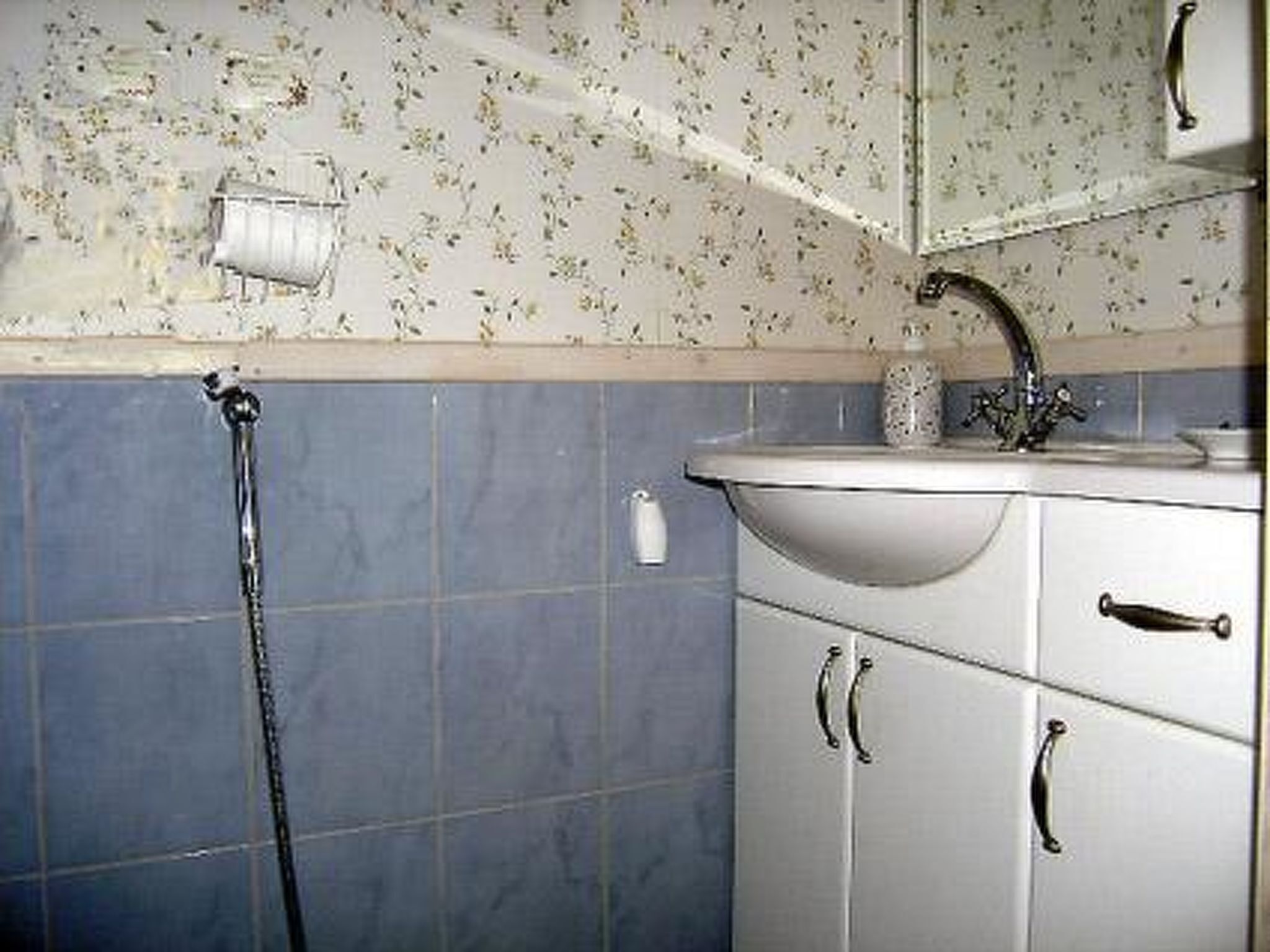 Un baño con lavabo, espejo y ducha.