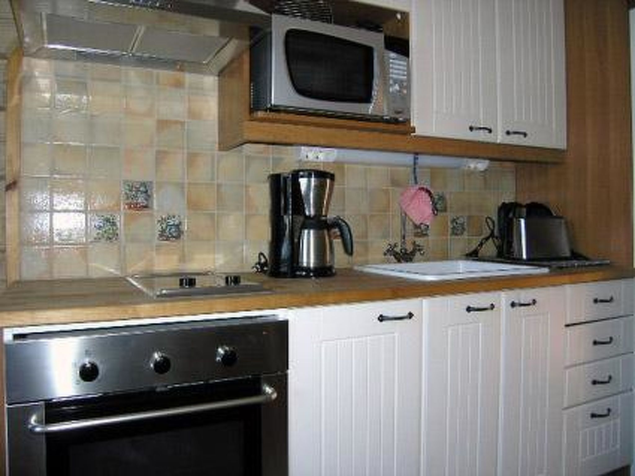 Een koelkast, een magnetron, kookgerei, borden en bestek