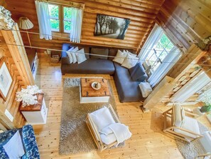 A log cabin interior with a sectional sofa, a coffee table, a rug, and a painting on the wall. - Hartolan ilo by Interhome (Hartola)