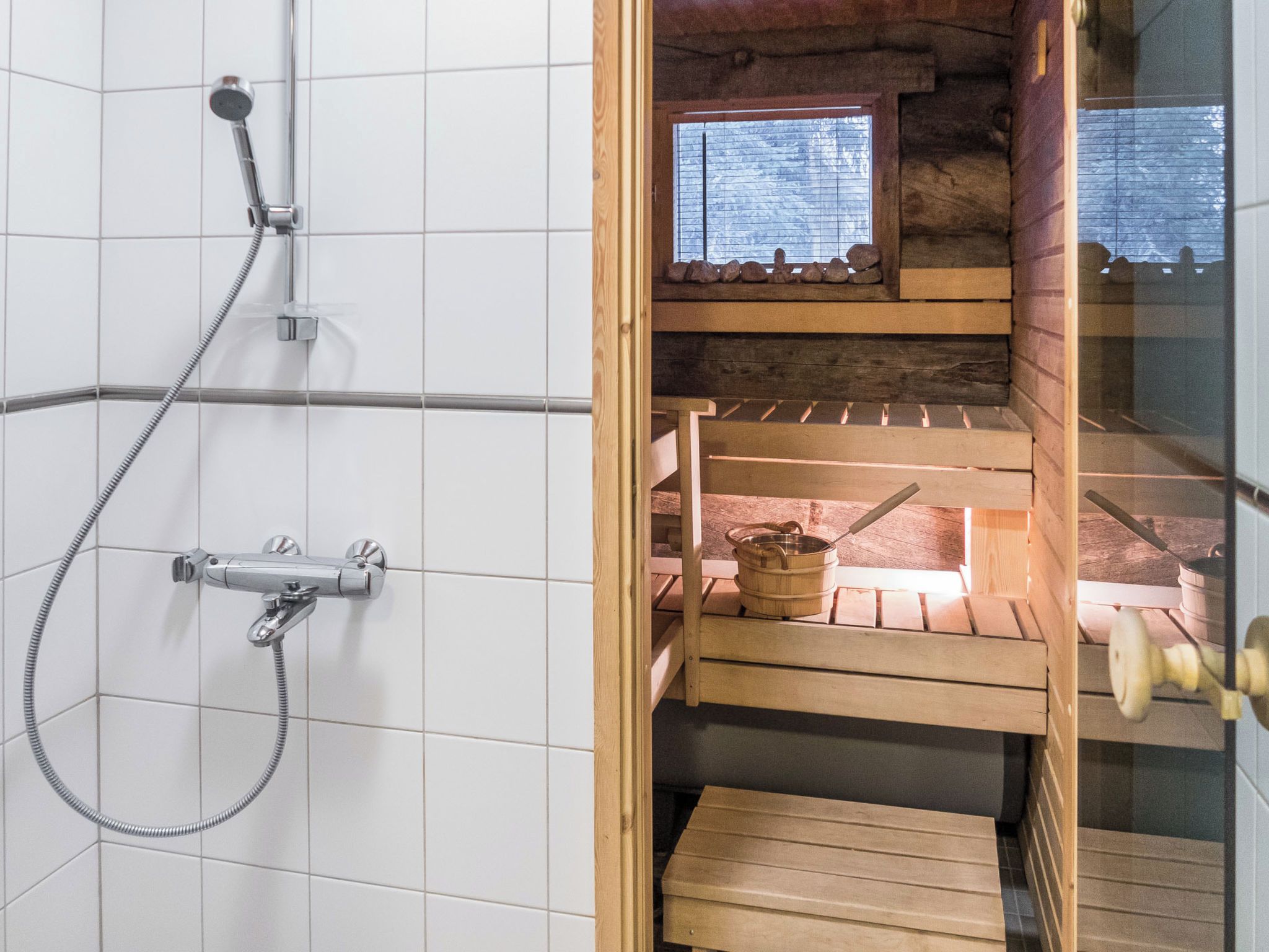 A shower with a handheld showerhead and a wall-mounted faucet.