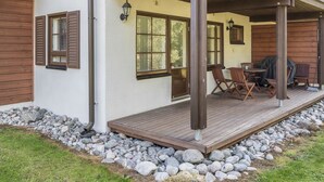 A covered patio area with outdoor seating and a grill. - Alppitalo punatähti 7 as 2 by Interhome (Nilsiä)