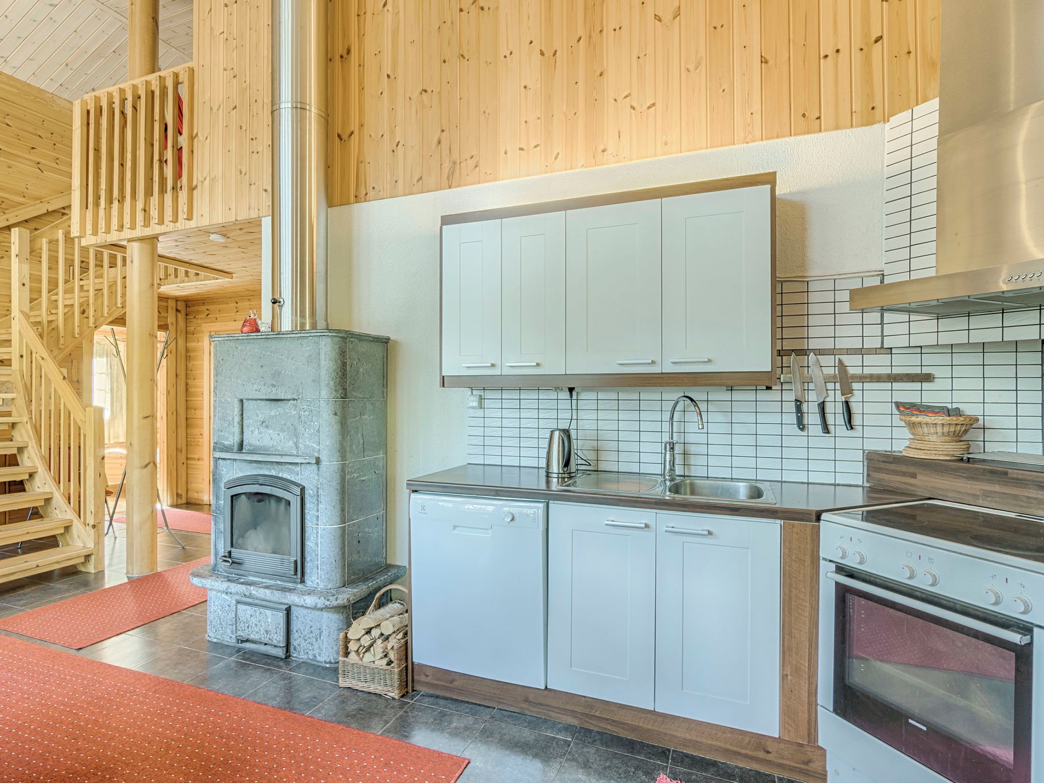 A kitchen with white cabinets, a built-in stove, and a stainless steel sink.