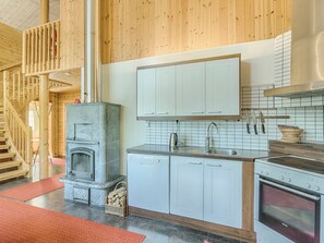 A kitchen with white cabinets, a built-in stove, and a stainless steel sink.