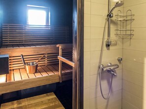 A shower with a handheld showerhead and a wall-mounted faucet.