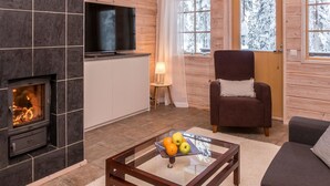 A cozy living room with a fireplace, a television, and a comfortable seating area.