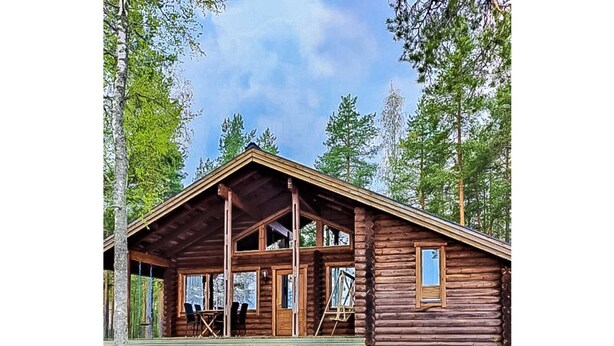 A log cabin with a porch, a ladder, and a small outdoor seating area. - Mäntyniemi by Interhome (Konnevesi)