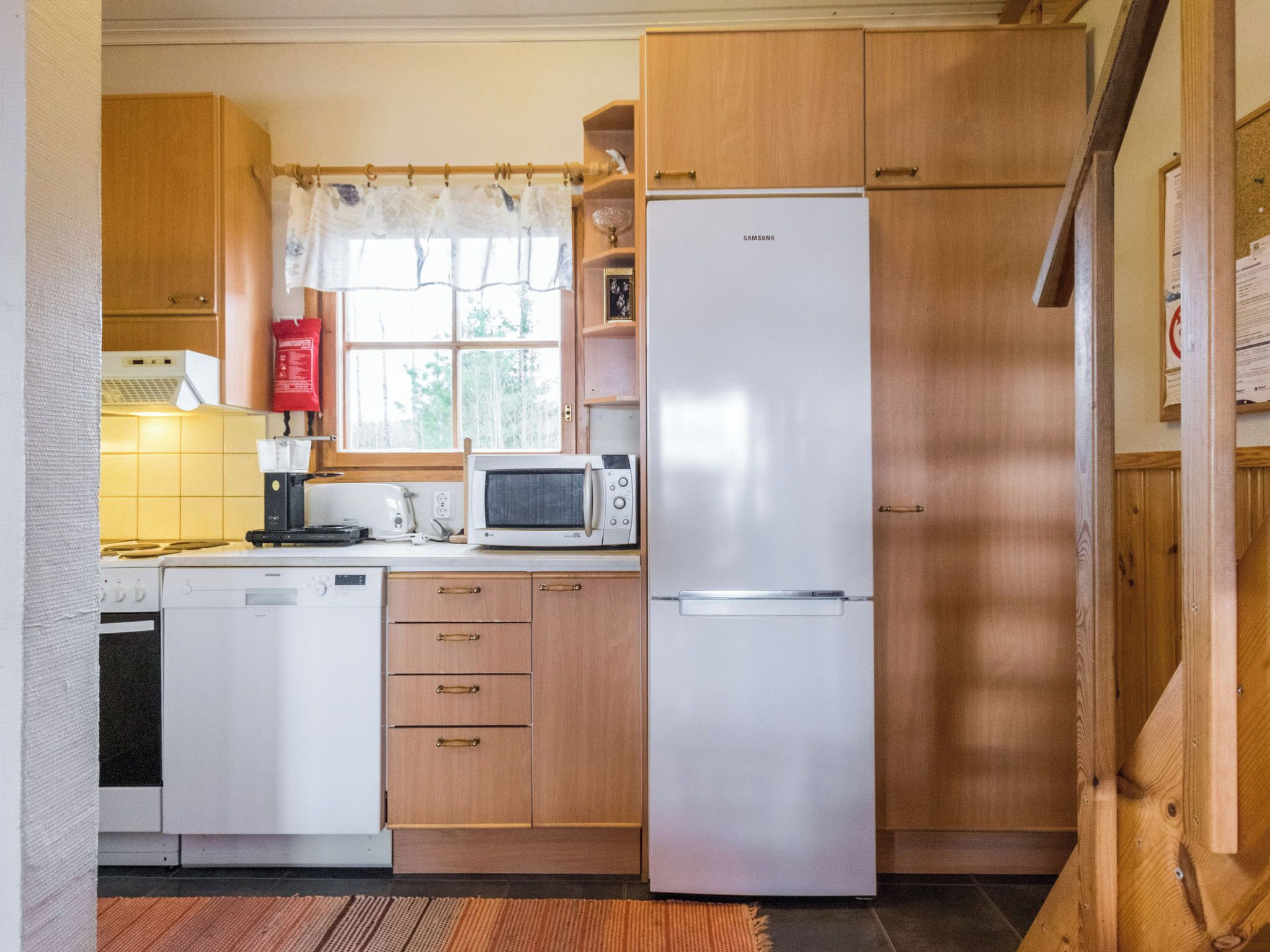 A compact kitchen with a microwave, refrigerator, and dishwasher.