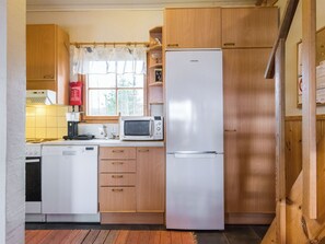 A compact kitchen with a microwave, refrigerator, and dishwasher.