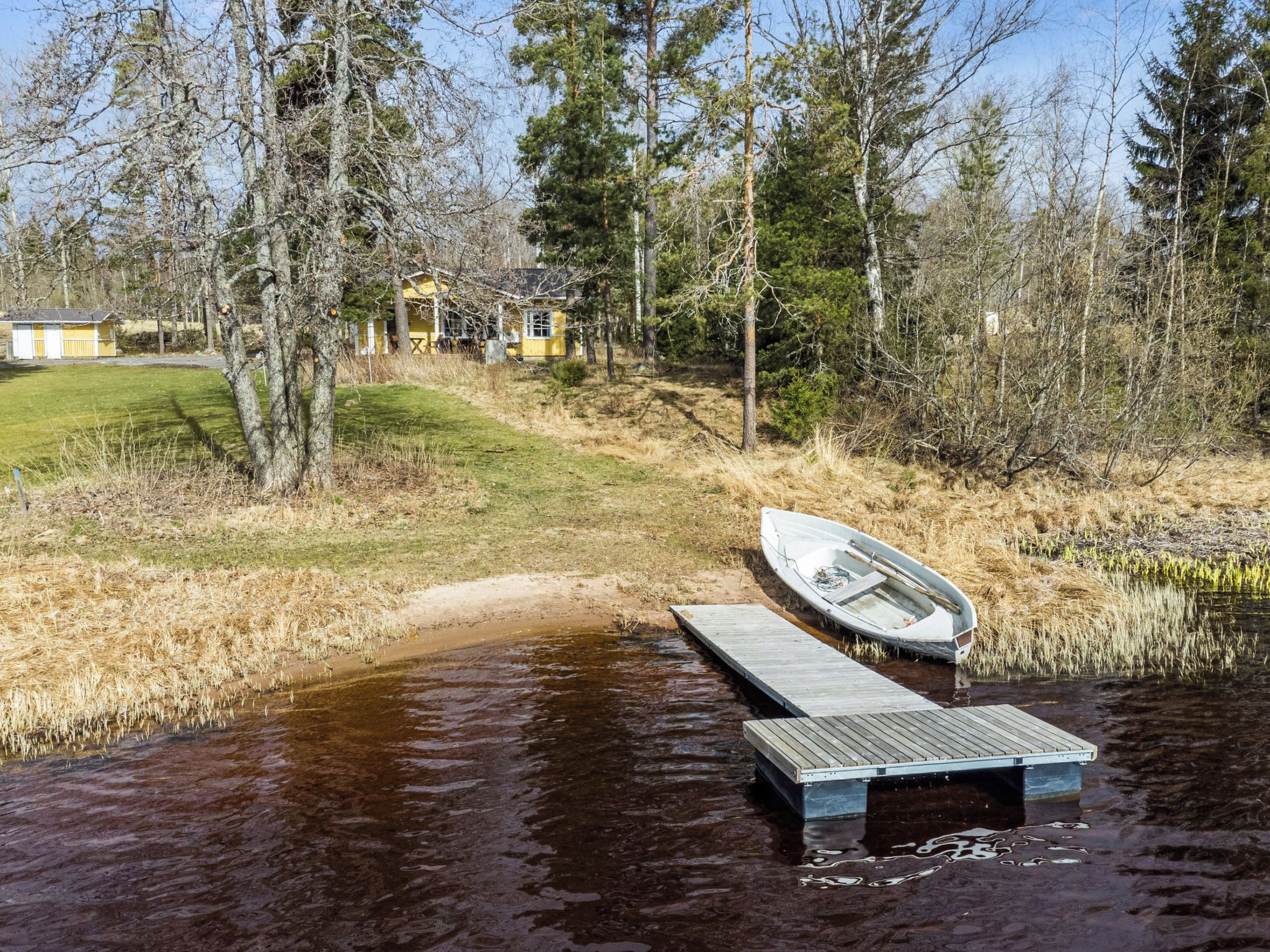 A wooden dock extending into a body of water with a small boat on it.