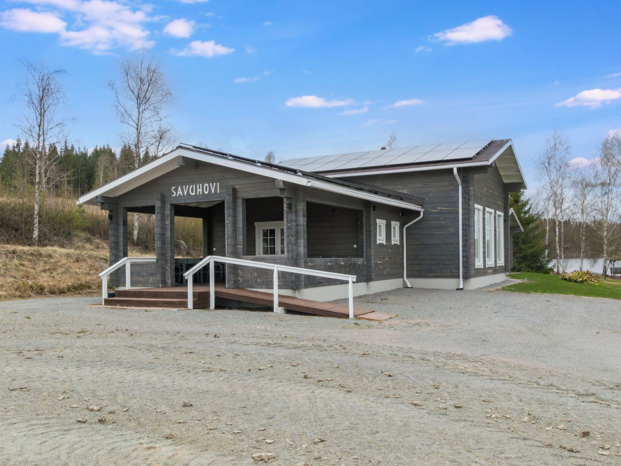 A building with a name sign 'SAVUHOVI' and a covered entrance with steps.