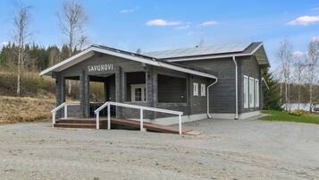 A building with a name sign 'SAVUHOVI' and a covered entrance with steps.