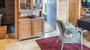 A wooden interior with a kitchen area featuring cabinets and a dining table. - Pikku-metso by Interhome (Kuusamo)